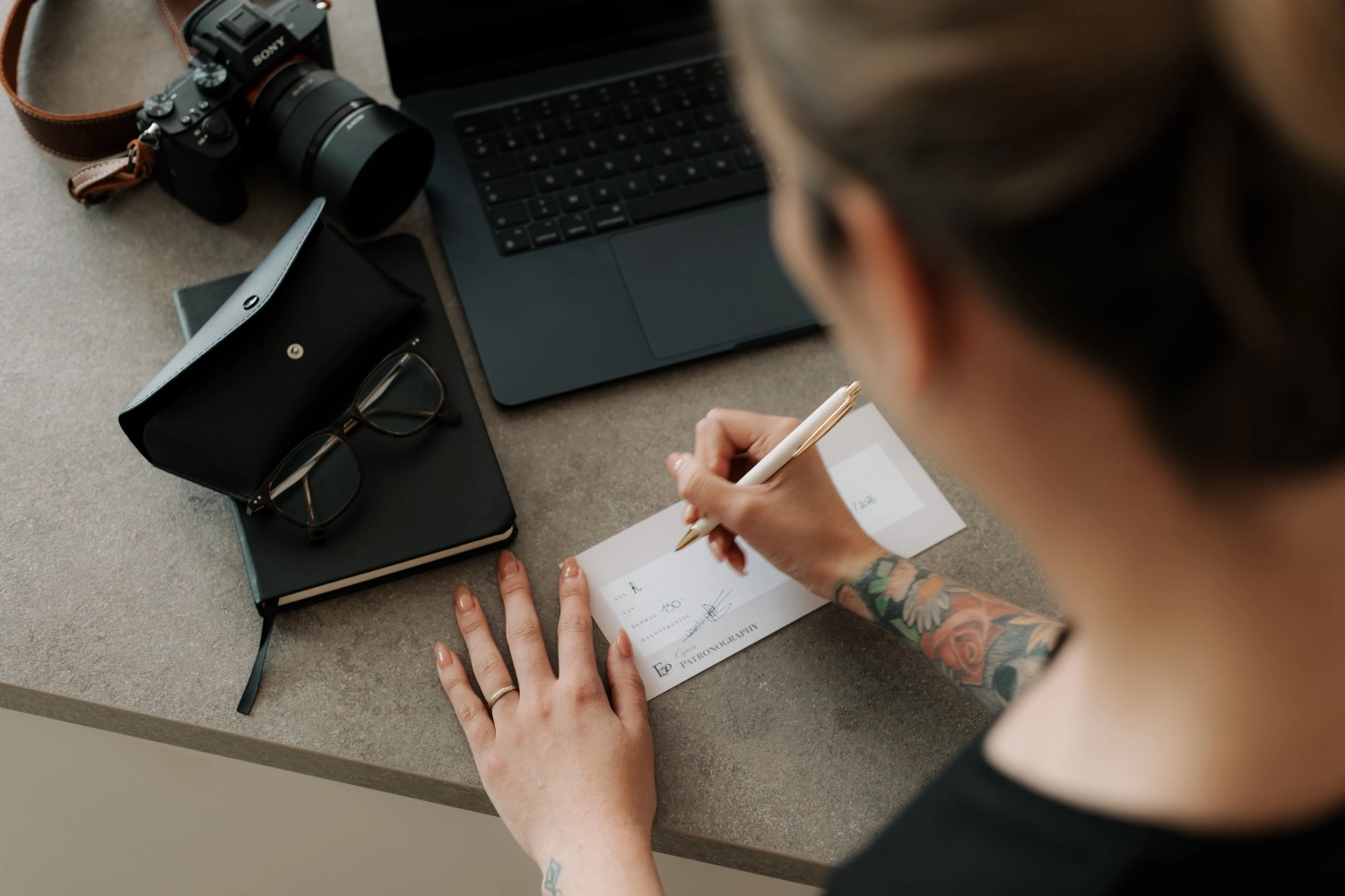 Fotograaf bezig met een cadeaubon te schrijven